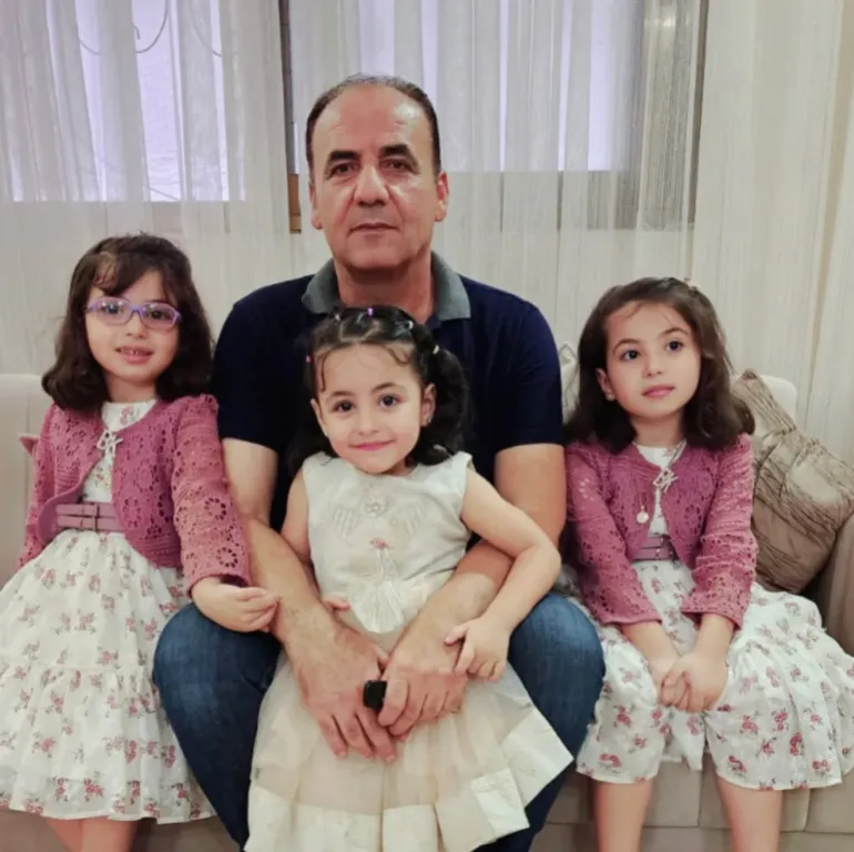 Tala's father with his grandchildren [Eman Abu Zayed/Al Jazeera]