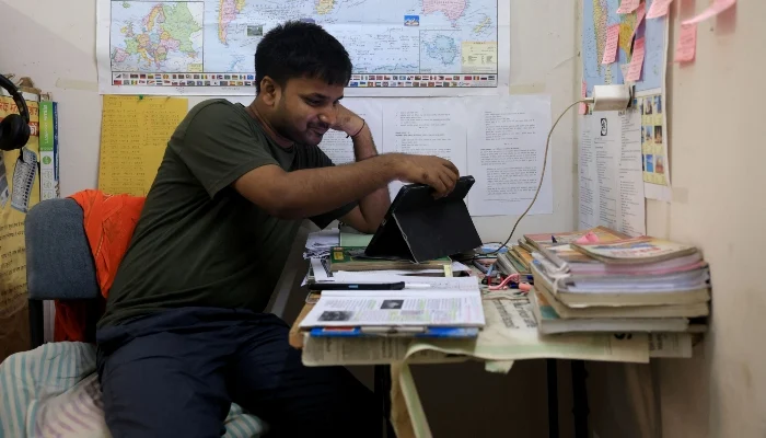 Ashok Kumar, 25, a civil service aspirant, uses his tablet as he studies inside his one room rented flat in New Delhi, India, July 29, 2026. — Reuters