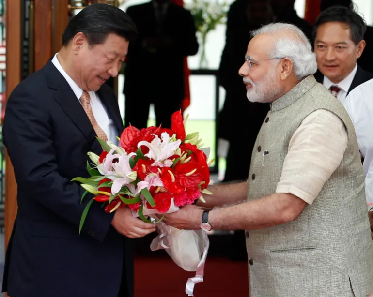 India’s Prime Minister Narendra Modi presents a bouquet to China’s President Xi Jinping before their meeting in the western Indian city of Ahmedabad, on September 17, 2014