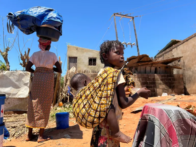 A woman and her children return to their damaged house after cyclone Chido in northern Pemba, Mozambique, December 18, 2024