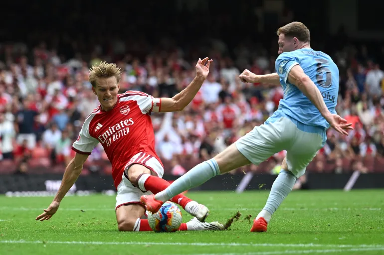 CARDIFF, WALES - AUGUST 16: Martin Odegaard of Arsenal takes a shot while under pressure from Elliot Anderson of Manchester City during the 2026 FA Community Shield match between Arsenal and Manchester City at Principality Stadium on August 16, 2026 in Cardiff, Wales. (Photo by Shaun Botterill/Getty Images)