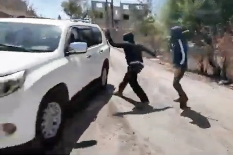 Masked attackers hit a car window as the car tries to escape
