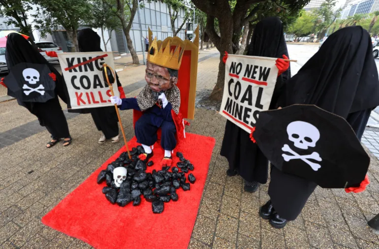 Members of Extinction Rebellion stage a protest with a figure depicting South African Minister of Mineral and Petroleum Resources Gwede Mantashe outside the Investing in African Mining Indaba conference in Cape Town, South Africa, on February 9, 2026