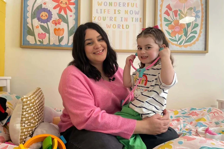 Image: Sofii Lewis holding her daughter Evie, both smiling
