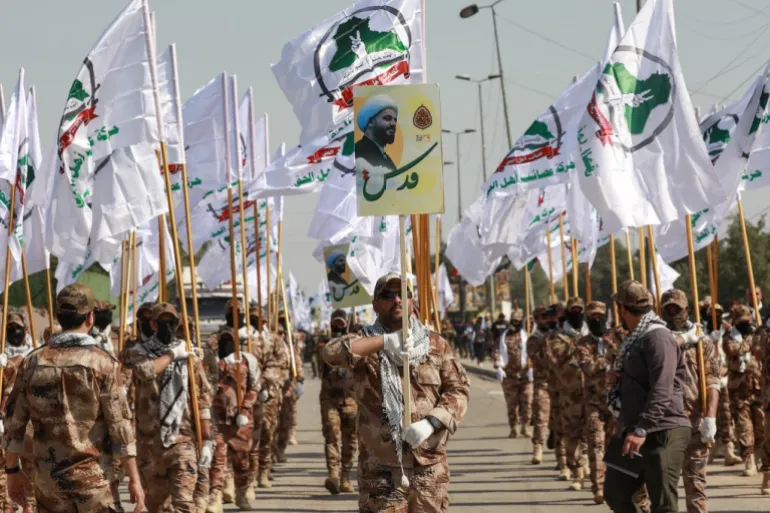 Fighters from Iraq's Hashed al-Shaabi (Popular Mobilisation Forces) carry flags as they rally to mark the annual Jerusalem day commemorations in Baghdad on March 28, 2025. [Murtaja Lateef/ AFP]