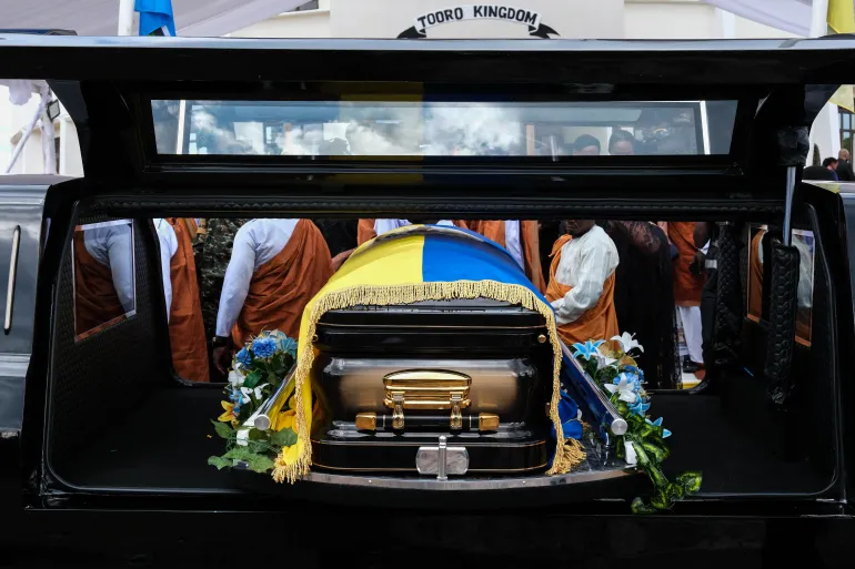 FORT PORTAL, UGANDA - SEPTEMBER 12: A casket containing the body of the Late Oyo Nyimba Kabamba Iguru Rukidi IV is loaded on a cortege after leaving the Karuziika Royal Palace ahead of the burial at the Karambi Royal Tombs on September 12, 2026 in Fort Portal, Uganda. An official burial is taking place for Oyo Nyimba Kabamba Iguru Rukidi IV, a traditional Ugandan ruler of the Tooro kingdom, who died aged 34 on August 27, 2026, while being treated for a critical illness in the United States. In the wake of the king's death, a dispute has broken out between the monarch's family and the succession committee over who should succeed him. (Photo by Hajarah Nalwadda/Getty Images)
