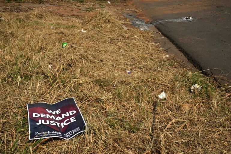 A poster is seen at a scene of a discovery of the body of a 38-year-old woman last week while jogging, in Kempton Park, east of Johannesburg, South Africa, Thursday, Sept. 17, 2026. (AP Photo/Themba Hadebe)