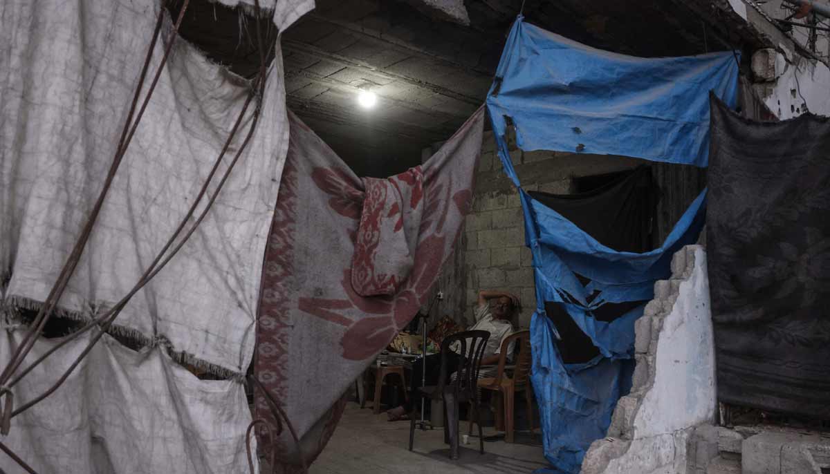 A displaced Palestinian man sits inside a heavily damaged building being used as a shelter in Khan Yunis in the southern Gaza Strip on September 19, 2026. — AFP