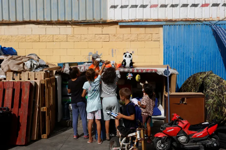 Migrant children take toys at an industrial area, following the mass crossing of migrants from Morocco, in Ceuta, Spain, September 21, 2026. REUTERS/Jon Nazca TPX IMAGES OF THE DAY