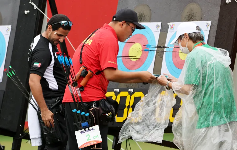 Asian Games - Aichi-Nagoya 2026 - Archery - Okazaki Central Park Multipurpose Square, Okazaki, Japan - September 28, 2026 China's Jinyi Liu places his targets into plastic bags due to the rain during his compound men's individual 1/16 elimination match against United Arab Emirates' Sultan Almenhali REUTERS/Anushree Fadnavis