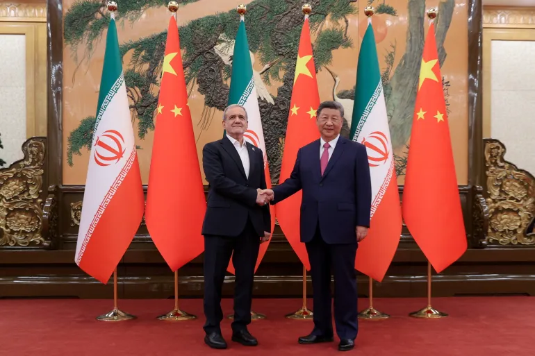 Iranian President Masoud Pezeshkian and Chinese President Xi Jinping shake hands as they meet in Beijing, China, on September 2, 2025