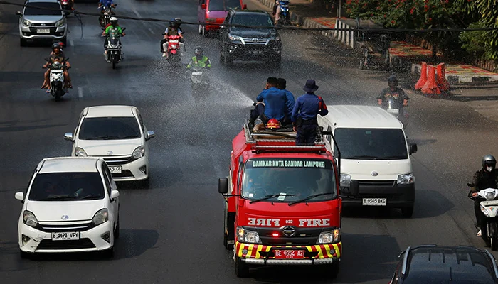 Firefighters spray water to clear volcanic ash following the Mount Anak Krakatau volcano eruption, in Bandar Lampung, Lampung province, Indonesia, September 6, 2026. — Reuters