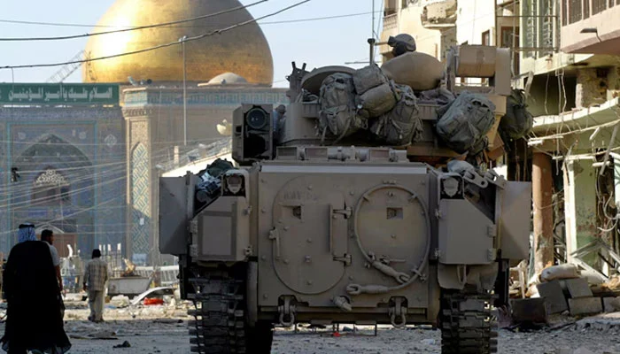A US Army Bradley armoured vehicle of the 1st Cavalry division guards a street leading from the cemetery to Imam Alis shrine, in Najaf, Iraq, August 27, 2004. — Reuters