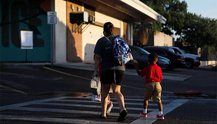 A parent walks their children on the first day of school in Tampa, Florida, US, August 10, 2021. — Reuters