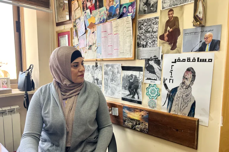 Rania Washaha looks at her brother’s photo in her office inside Birzeit University