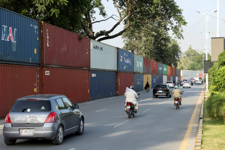 Traffic moves past shipping containers used to block the area, ahead of a planned march by jailed former Prime Minister Imran Khan's Pakistan Tehreek-e-Insaf (PTI) party, in Islamabad, Pakistan, on September 30, 2026 [Reuters]